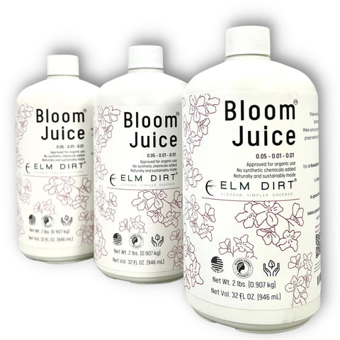 Elm Dirt Bloom Juice bottle on a potting bench boosts flowering plants with organic nutrients.