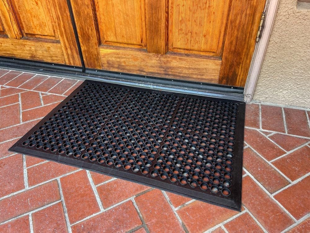 Envelor anti-fatigue mat 2-pack shows perforated design trapping dirt.