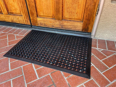 Envelor anti-fatigue mat 2-pack shows perforated design trapping dirt.