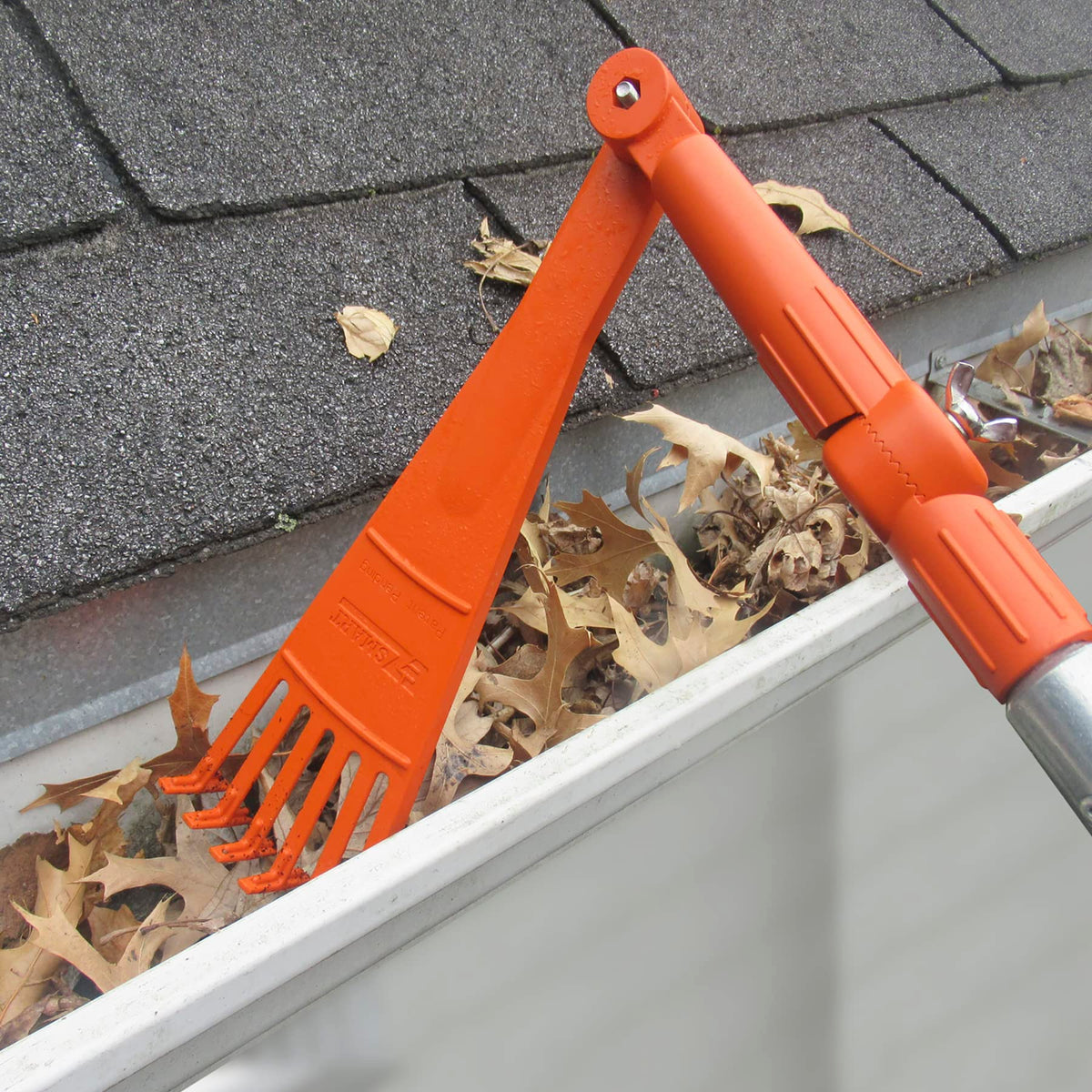 EZ SMART Mini Rake Head clearing leaves and debris from gutters from the ground.