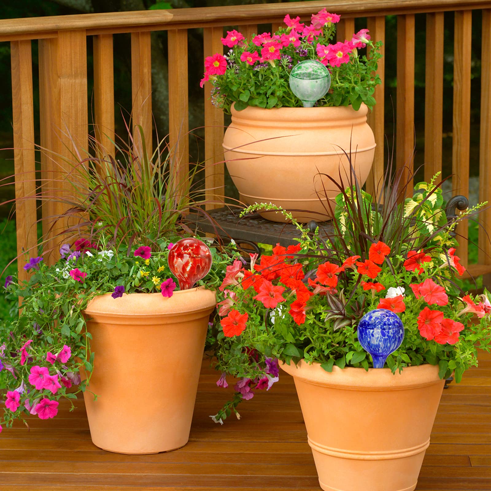 Glass watering globes from Fasmov blending with garden decor.