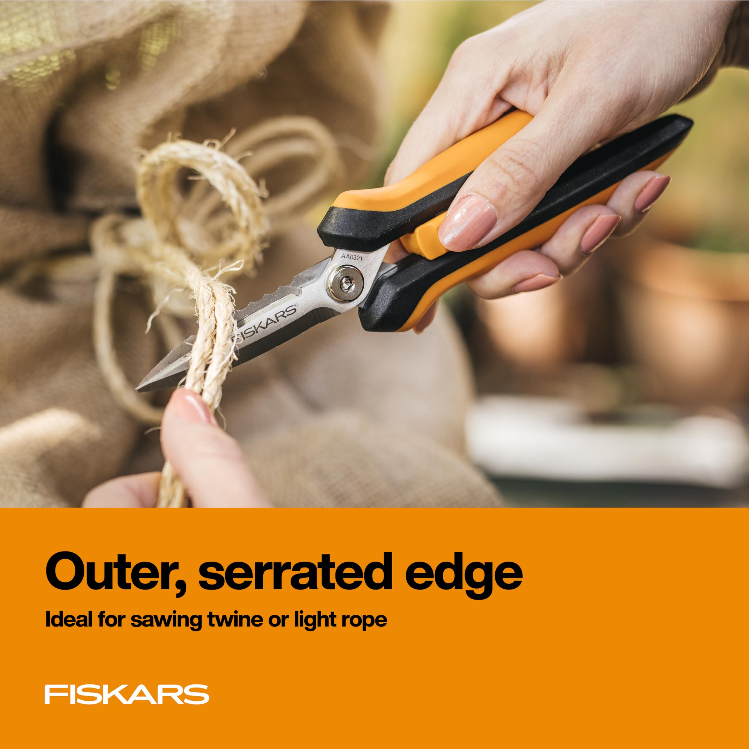 Fiskars 8-inch garden snips in action trimming stems.