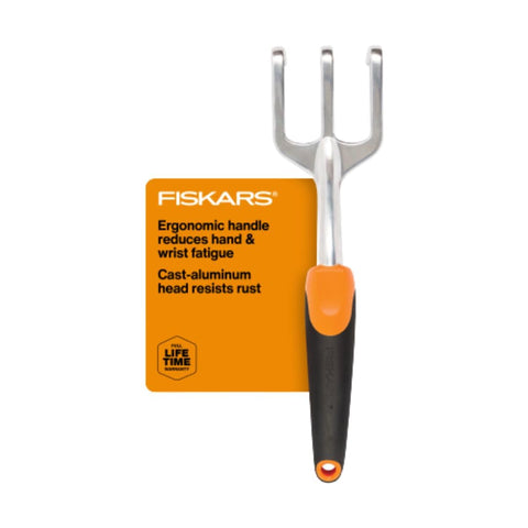 Fiskars Ergo Cultivator digging soil with a rugged aluminum head for deep aeration.
