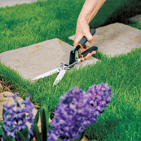 Fiskars grass shears serrated blade cutting action demonstrates durable performance.