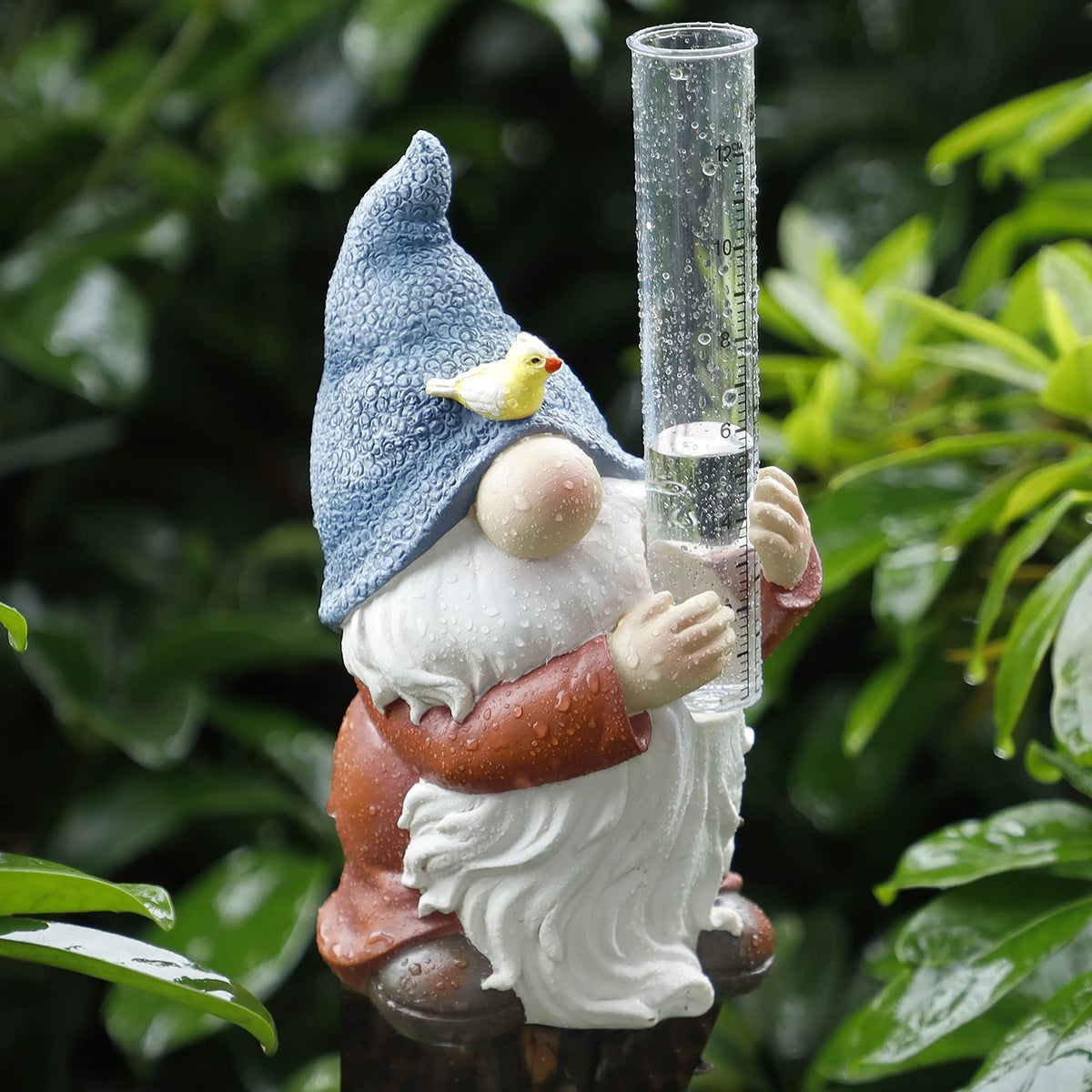 FORUP resin gnome rain gauge in a garden with clear inches and centimeters readings.