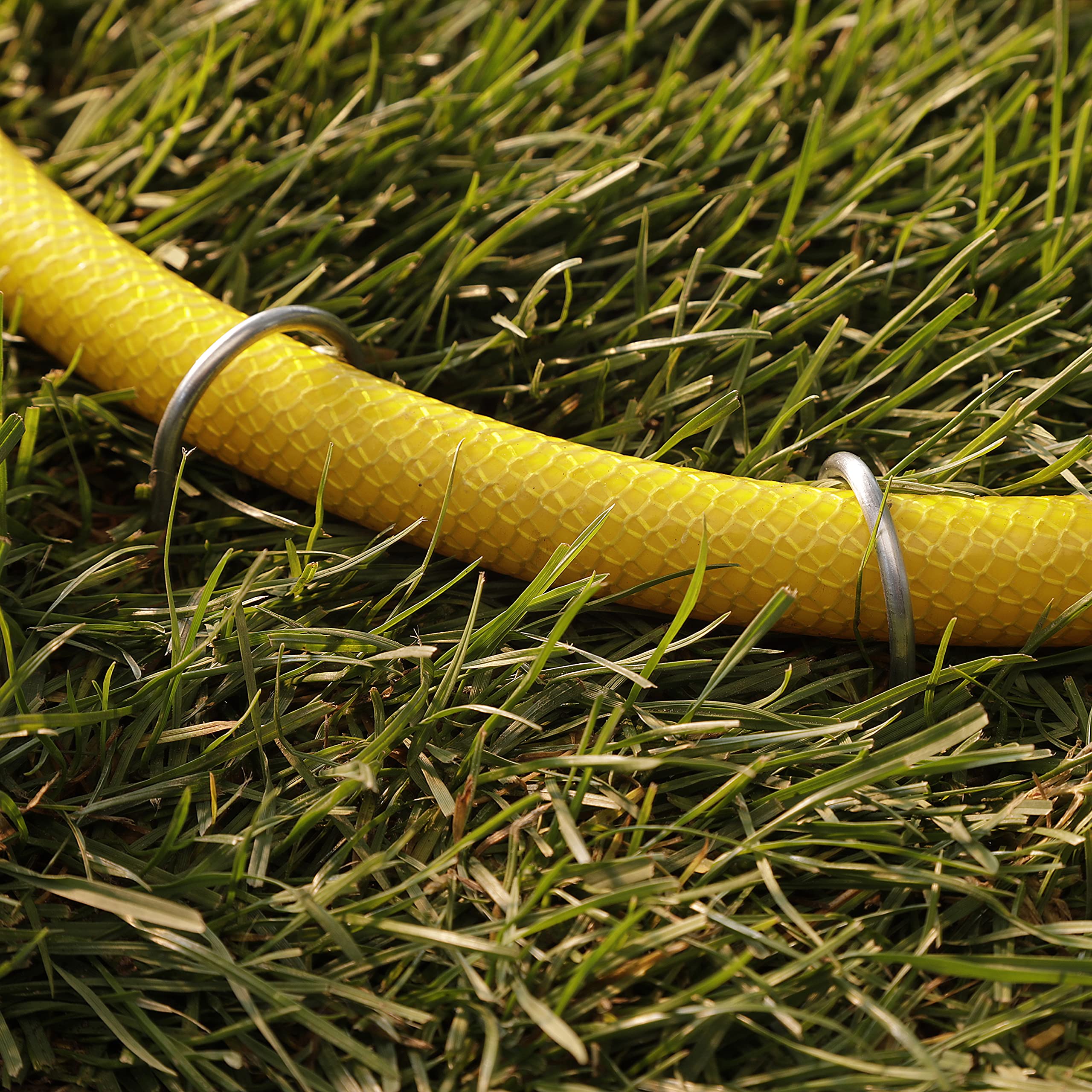 GardenMate landscape fabric anchor works for hoses and cables as well.