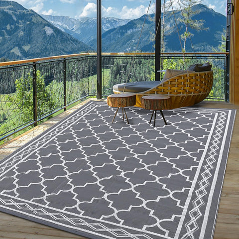 Garvee rug secured with corner loops and stakes on an RV campground