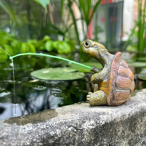 Generic Charming Resin Turtle Fishing Statue on a rock enriches outdoor garden spaces.