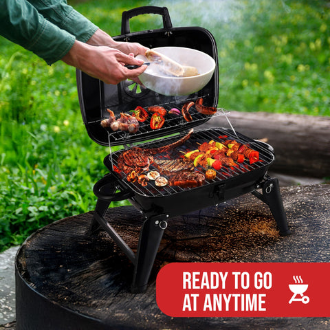 Grill Trade tabletop charcoal grill setup on a picnic table for quick meals.