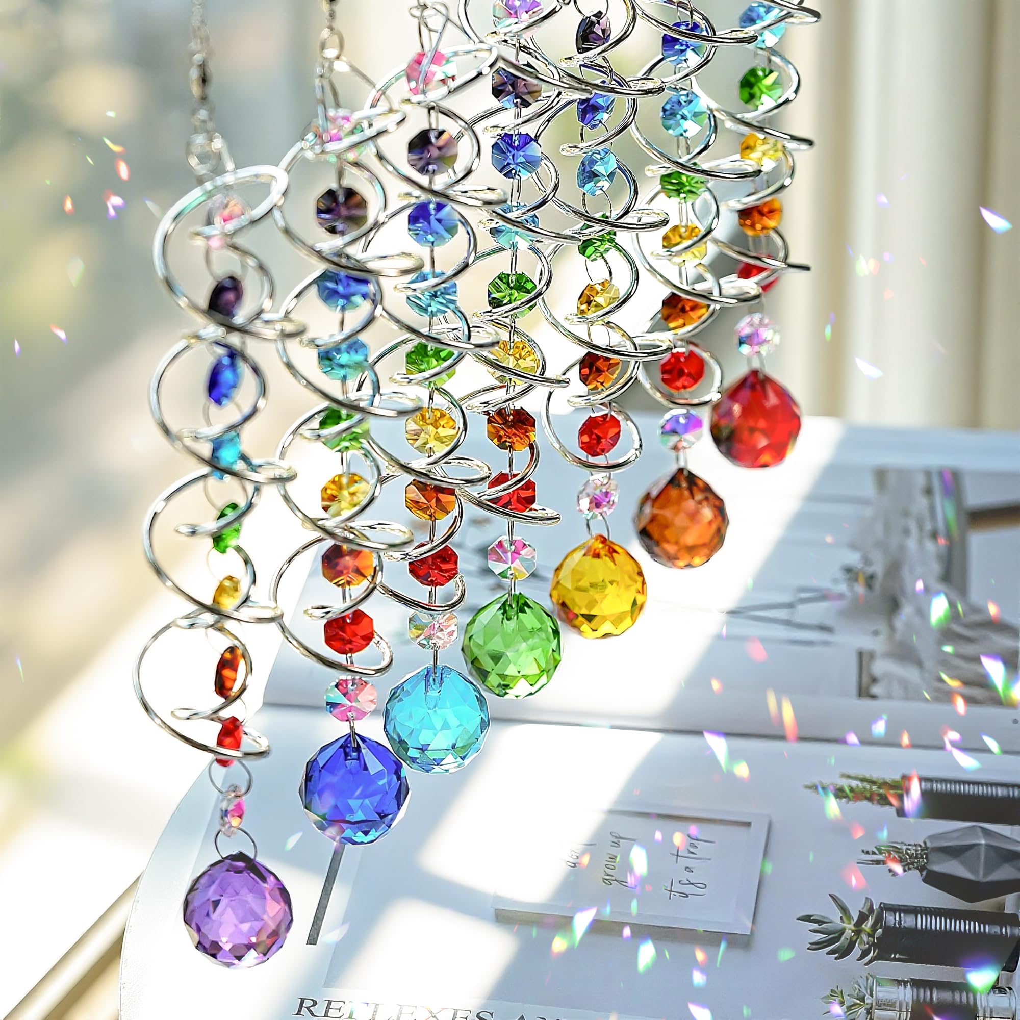 H and D Hyaline and Dora rainbow crystal prisms reflect sun across garden paths.