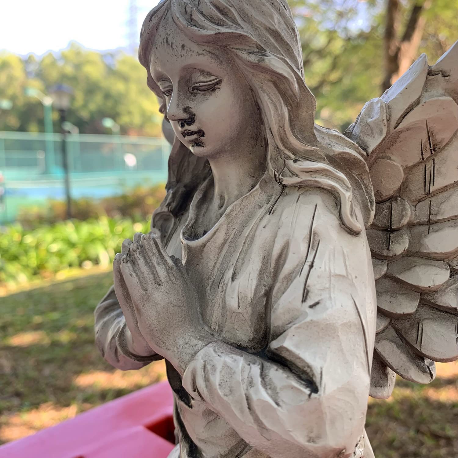 Handsider weatherproof angel statue endures sun and rain with grace.