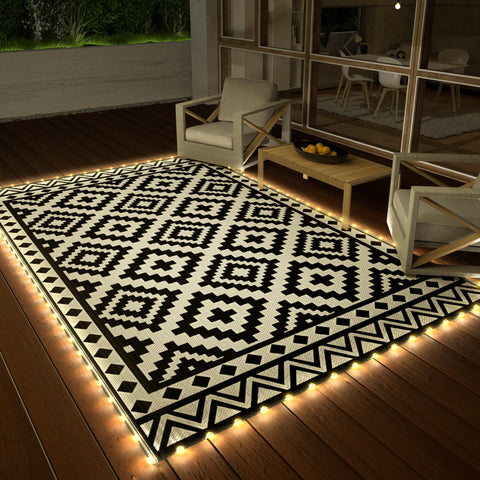 Haushof outdoor rug with LED strip lights around edge for ambient evenings.