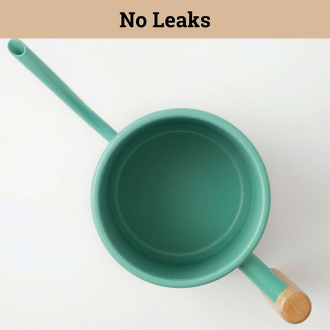 Matte green decorative watering can that complements indoor plant decor.