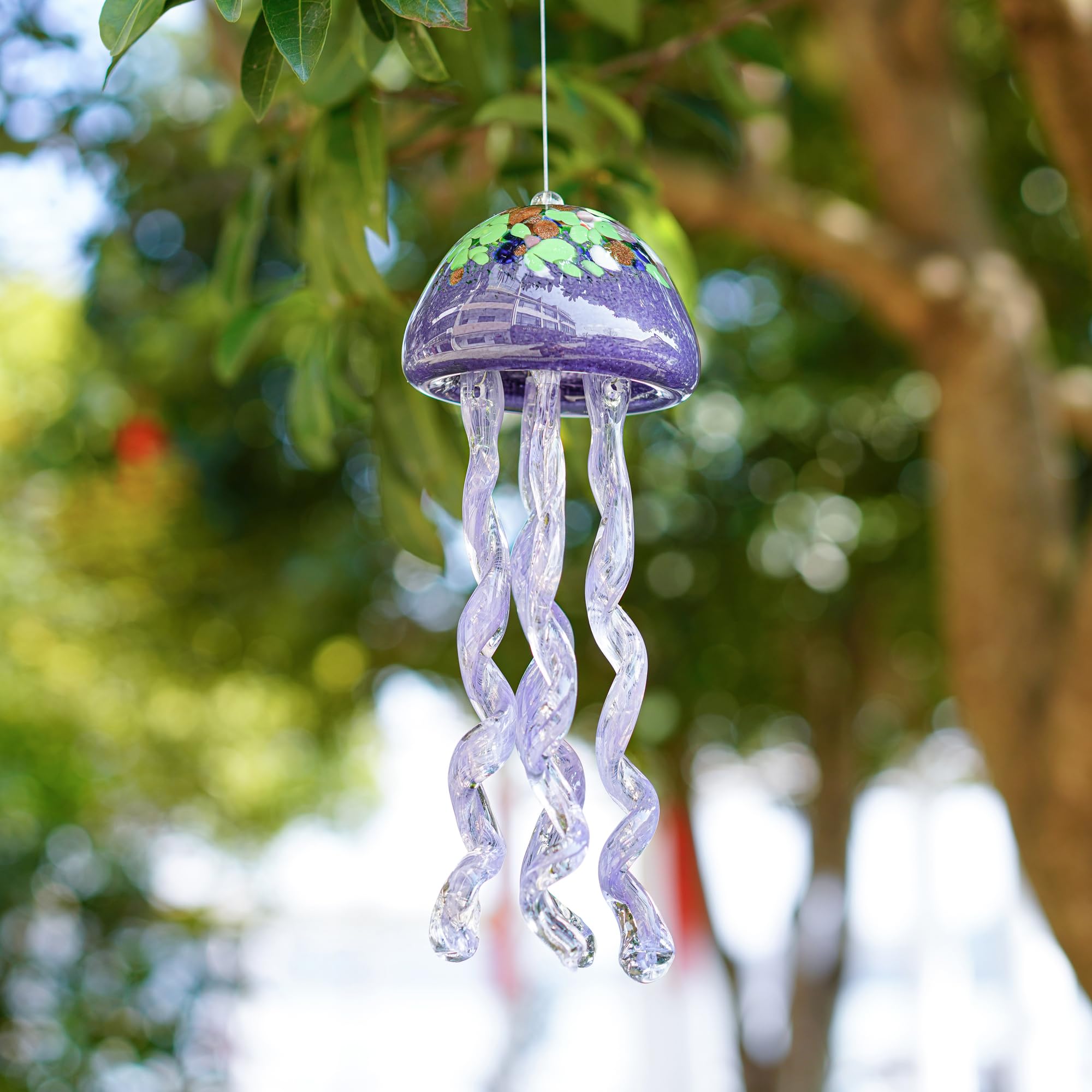 H&D Hyaline and Dora wind chime hangs from brass hook for durable outdoor installation.