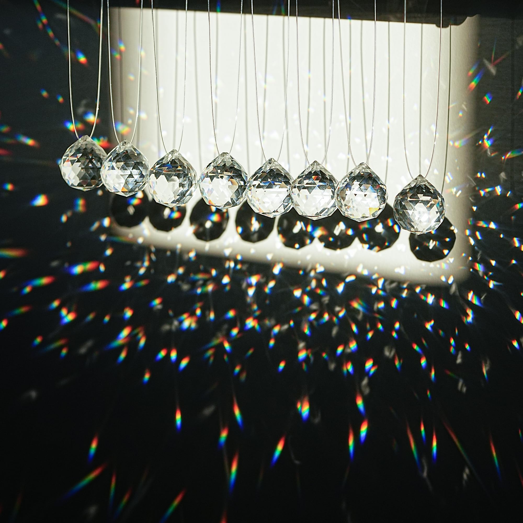 HDCRYSTALGIFTS clear crystal ball prism hanging in a window casts vivid rainbows.