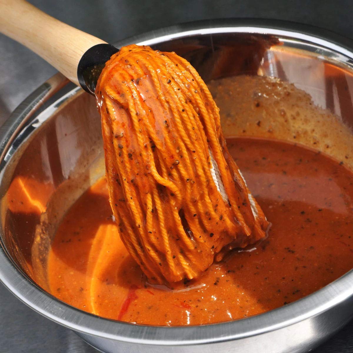 Hedume BBQ mop applying glaze to steak for even flavor.