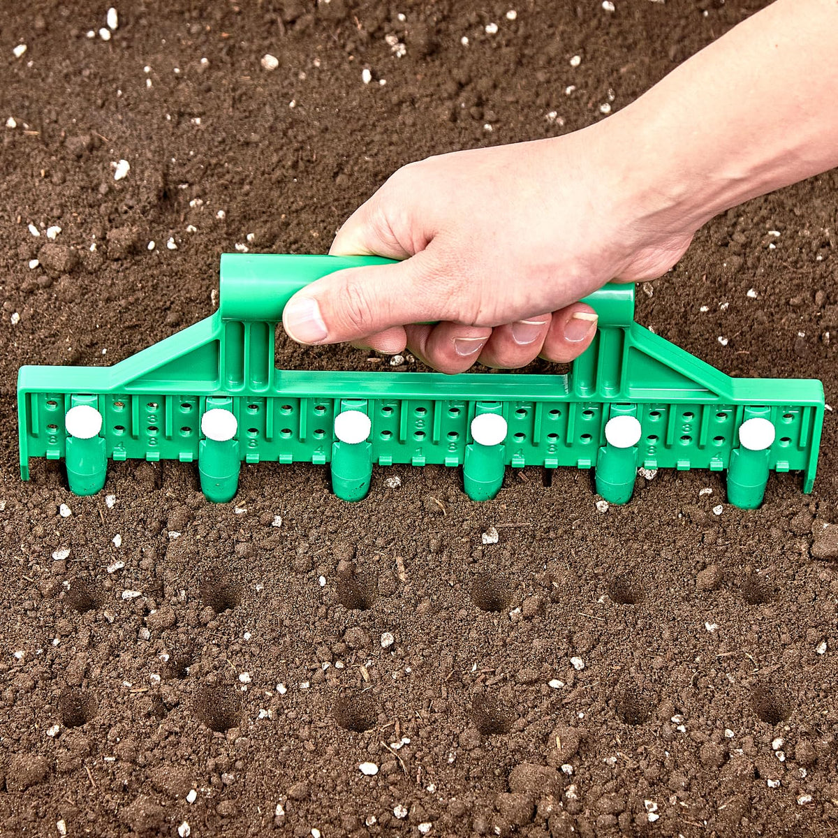 HHTHH Seed Dibber with green handle and pins for precise seed spacing.