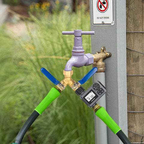 Hourleey brass splitter connected to two hoses in a garden setup