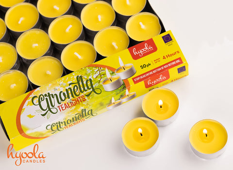 Hyoola citronella tealight glowing beside seating outdoors for ambience.