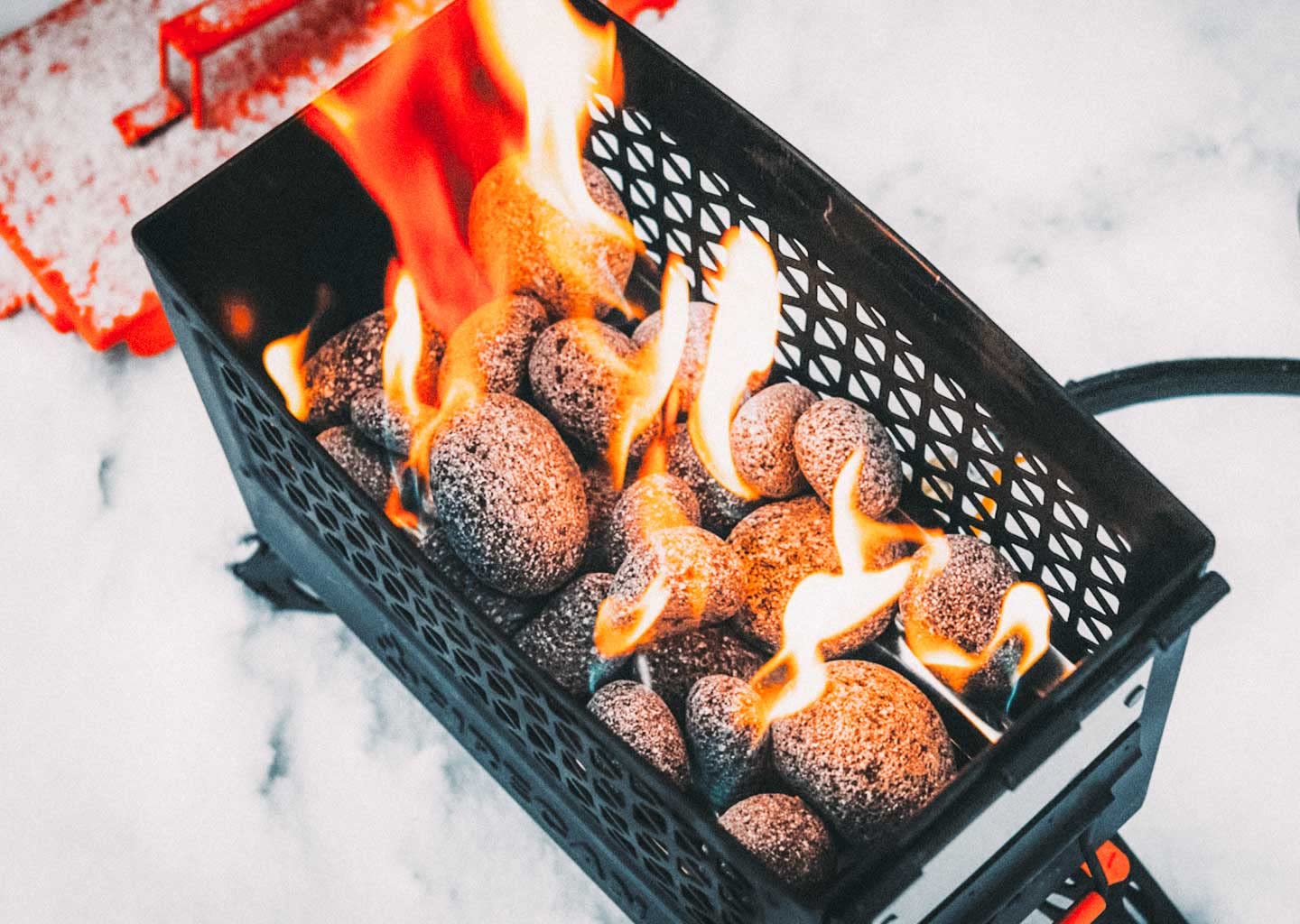 Ignik FireCan lava rocks nest around burners to enhance heat retention.