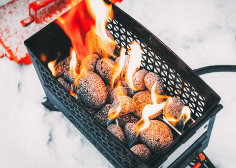 Ignik FireCan lava rocks nest around burners to enhance heat retention.