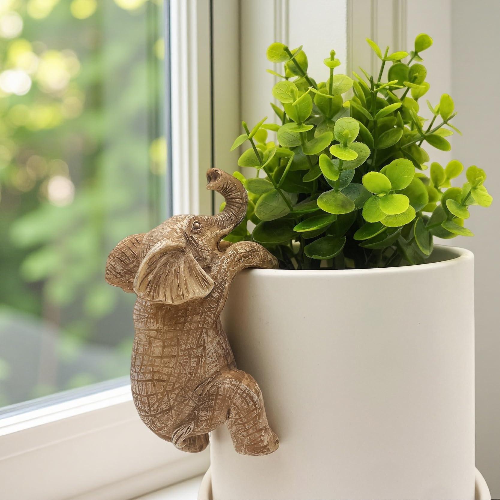 JARPSIRY elephant hugger perched on a fence adds whimsical garden charm.