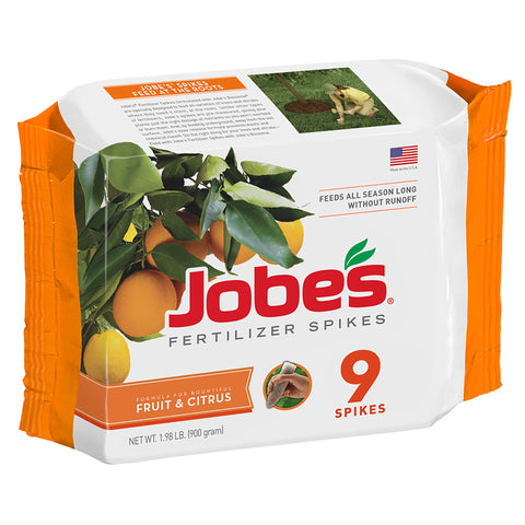 Jobe's Organics fruit citrus fertilizer spikes being inserted around dripline for simple placement.
