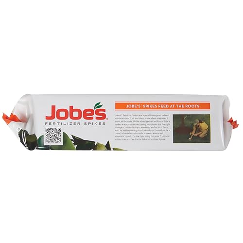 Jobe's Organics spikes being inserted around a tree's dripline for targeted feeding.