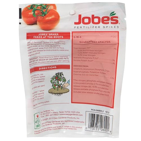 Jobe's Organics tomato spikes being inserted around plant roots for steady nutrition