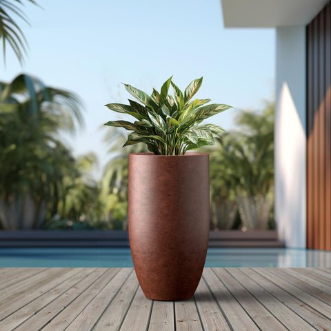 Kante 24-Inch Round Concrete Planter placed on a patio with plants