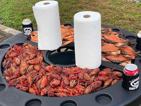 King Kooker serving table set up on the beach for seafood meals.