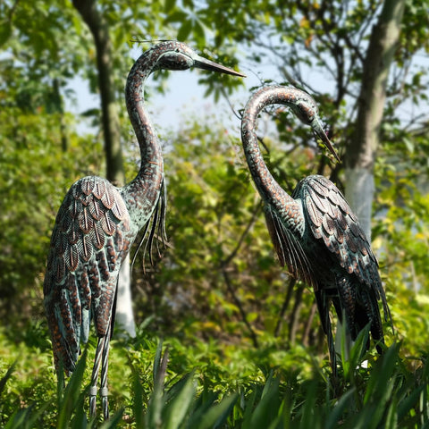 Kircust heron yard art in preening pose enhances pond-side focal point.