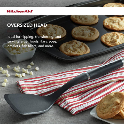 KitchenAid Gourmet Large Solid Turner in use for flipping and serving foods.
