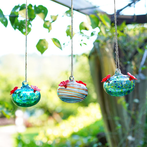 KRISININE outdoor décor feeder shines in sunlight beside garden windows.