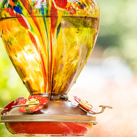 LaElvish Garden hummingbird feeder blue glass close-up adds vibrant color to outdoor decor.