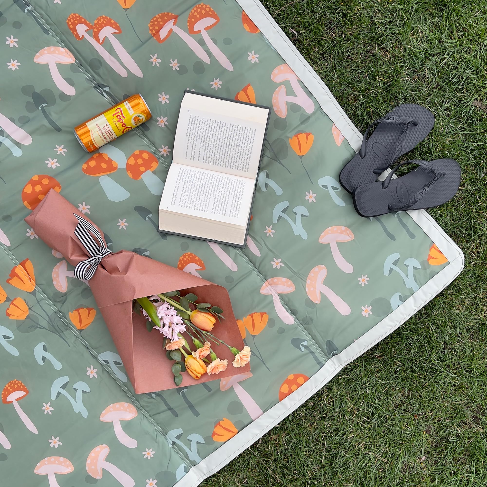Little Unicorn XL picnic blanket on damp sand showing water-resistant fabric