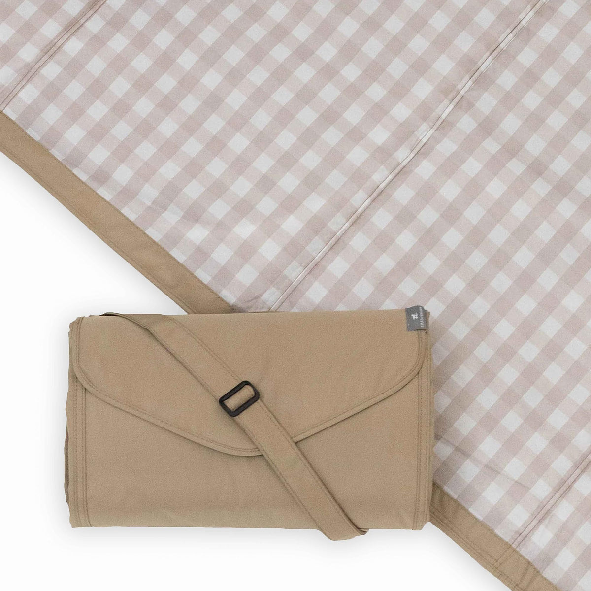 Little Unicorn xl picnic blanket folded with shoulder strap for easy transport.