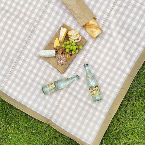 Little Unicorn xl picnic blanket over-the-shoulder strap for hands-free carrying.