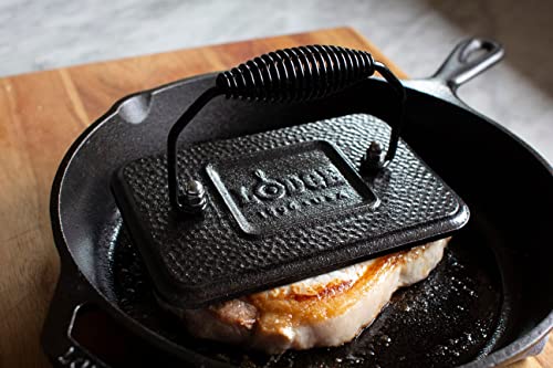 Lodge grill press used to press bacon or burgers on the stovetop for even searing.