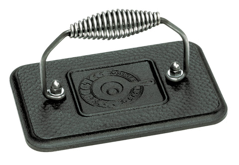 Lodge grill press with cool-grip spiral handle for safe, comfortable burgers on the stovetop.