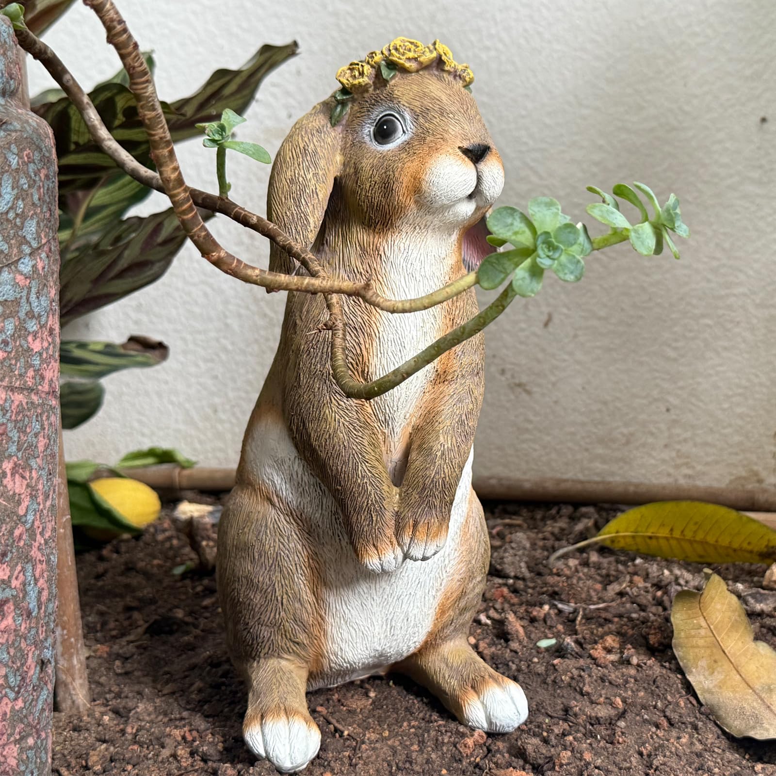 Lonyin Deco bunny statue placed among flowers in a garden bed