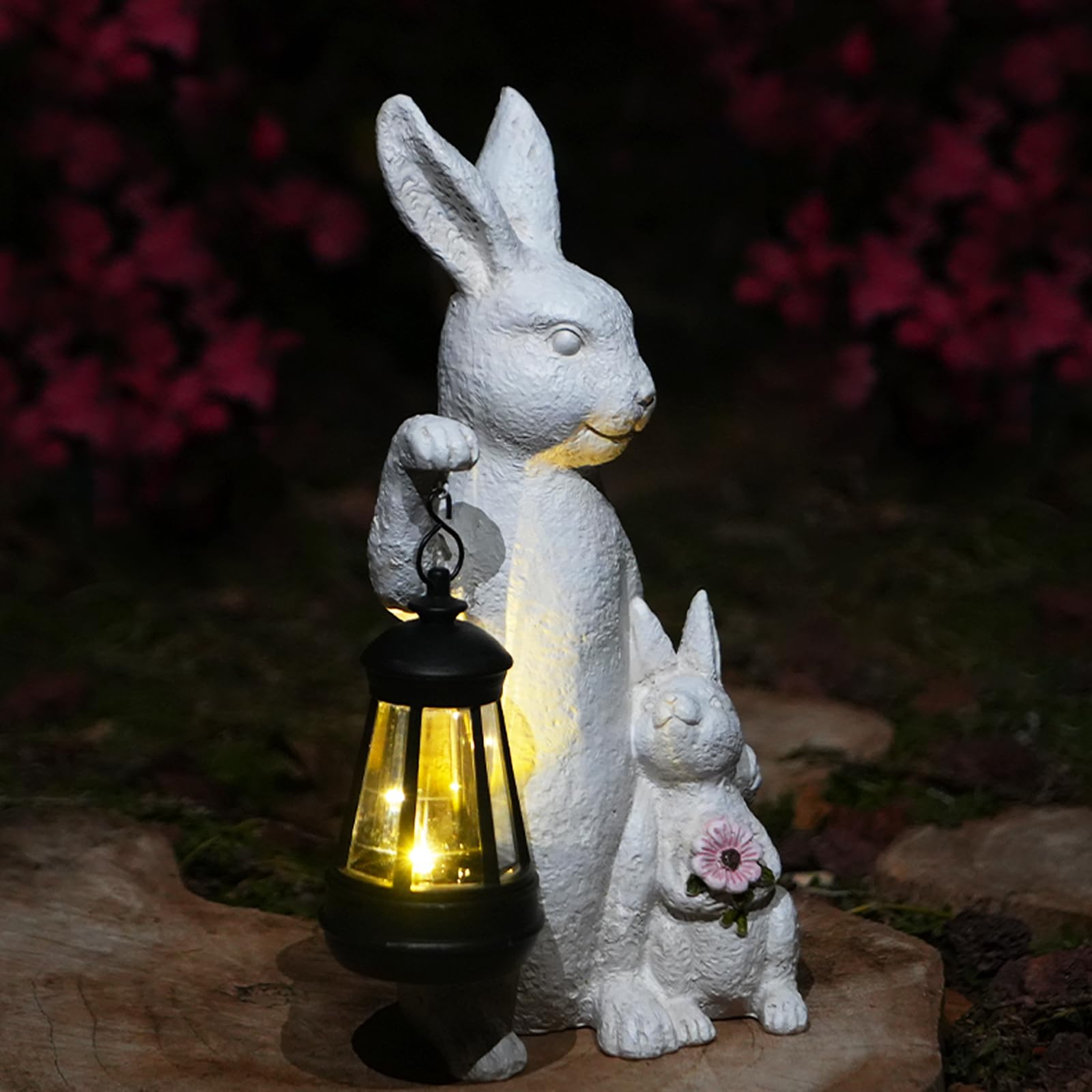 LXOUMEI solar bunny statue with lantern lights your garden at dusk.