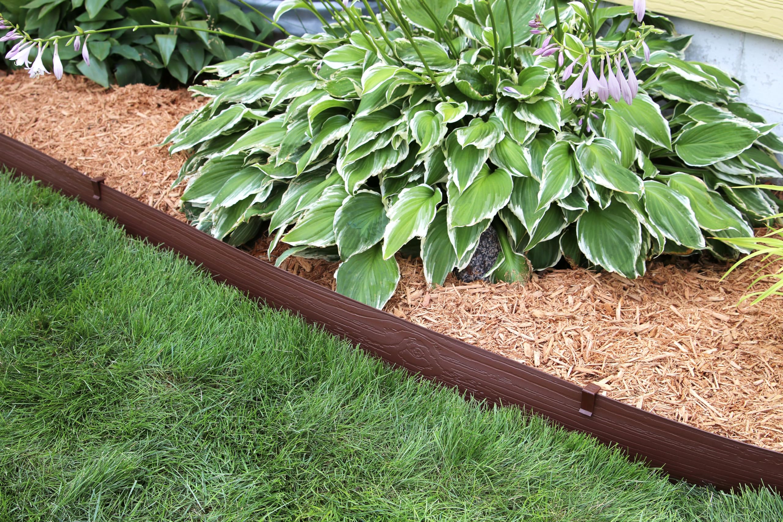 Brown Master Mark edging outlines a walkway border in a garden.