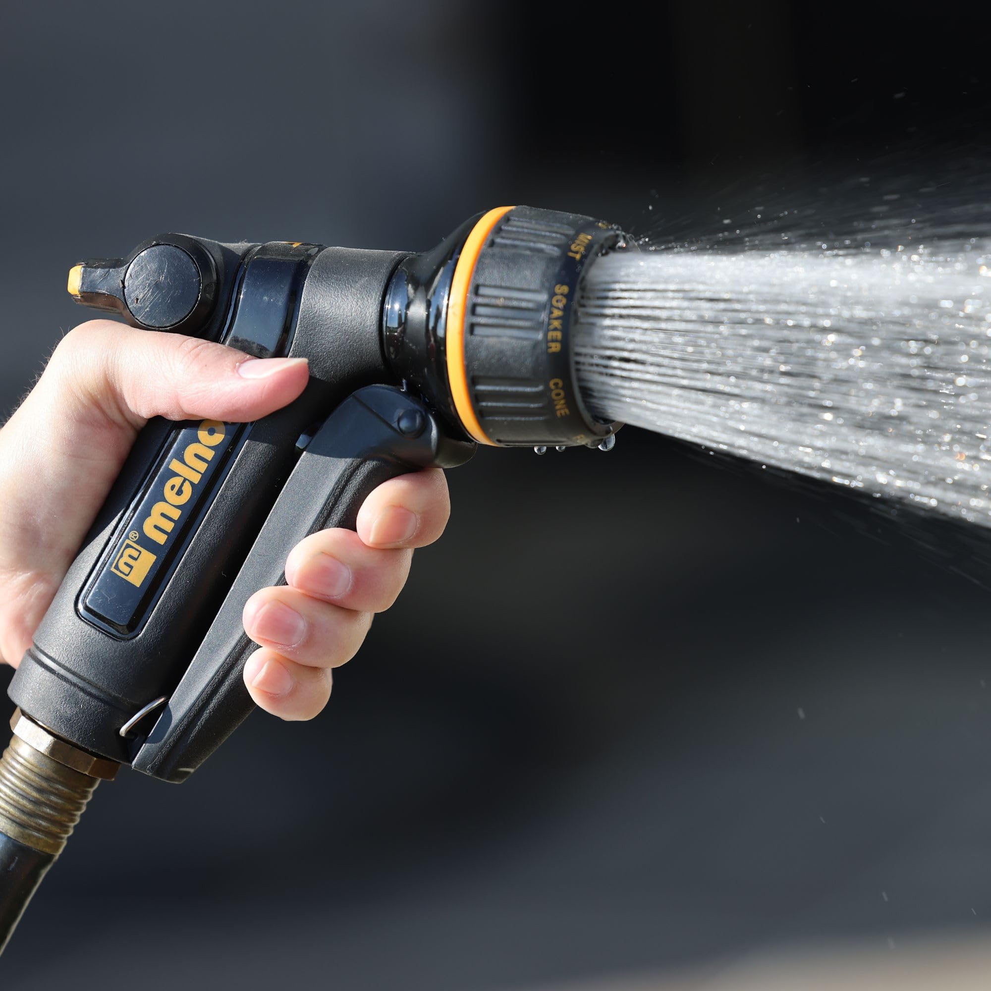 Melnor 65142AMZ heavy-duty nozzle shown in action for garden or car cleaning.