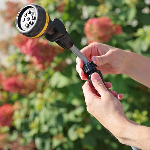 Melnor RelaxGrip being used to water plants along a fence line