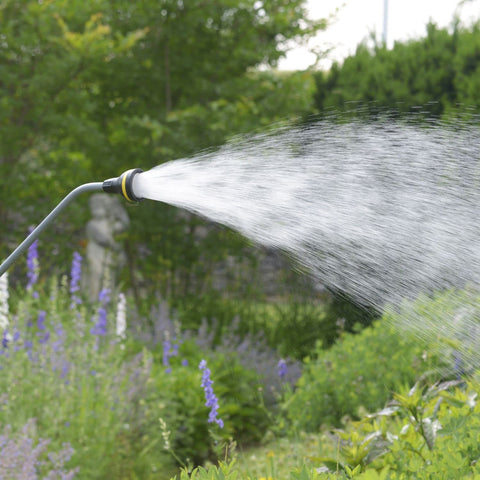 Ergonomic wand in action watering a seedling bed.