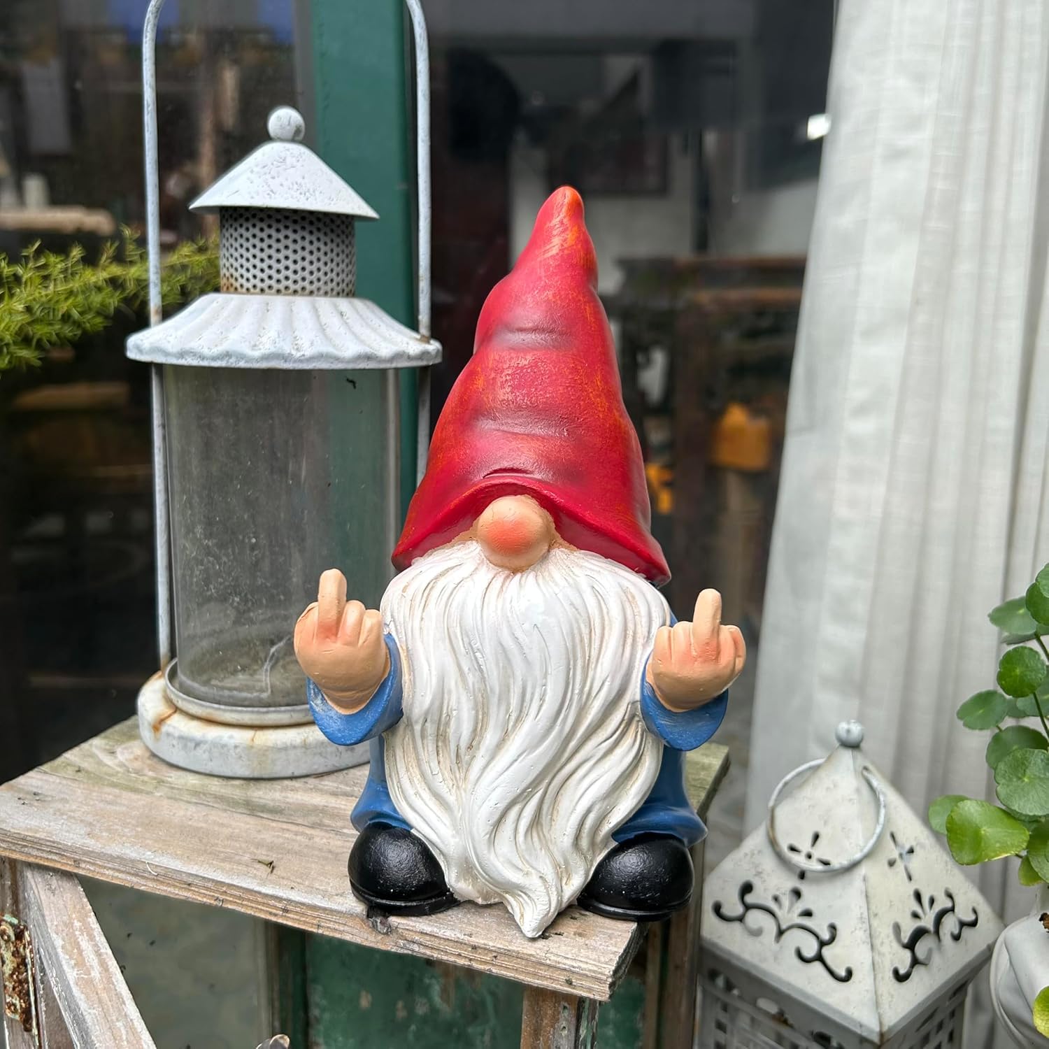 Middle Finger Gnome on lawn with cheeky expression for humorous yard charm.