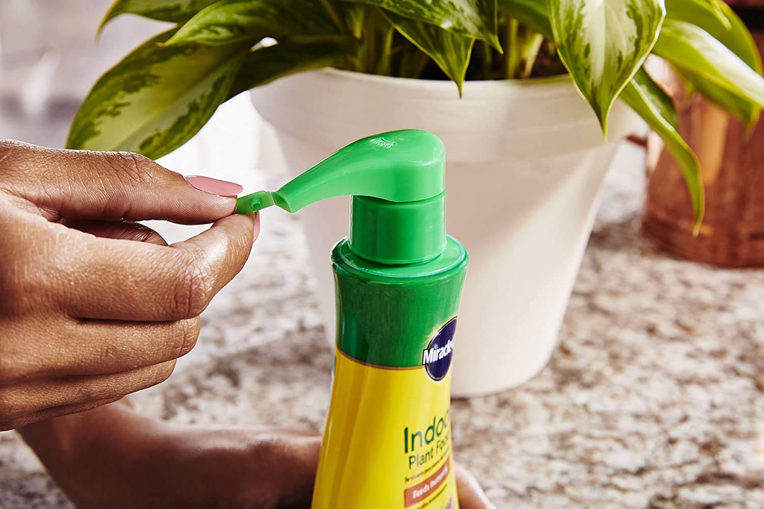 Miracle-Gro Indoor Plant Food bottle pour demonstrates easy feeding