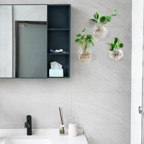 Mkono oblate vases highlight water plants with reflective light.