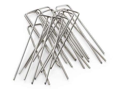 Modern Grower staples securing landscape fabric in soil for stable garden beds.